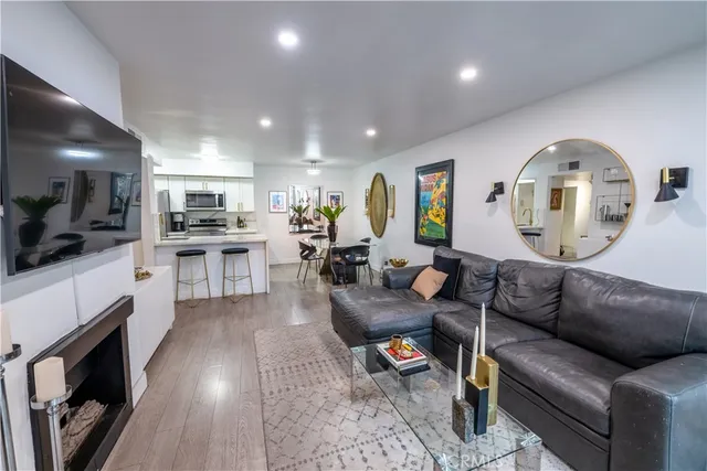 a living room with furniture a fireplace and a kitchen view