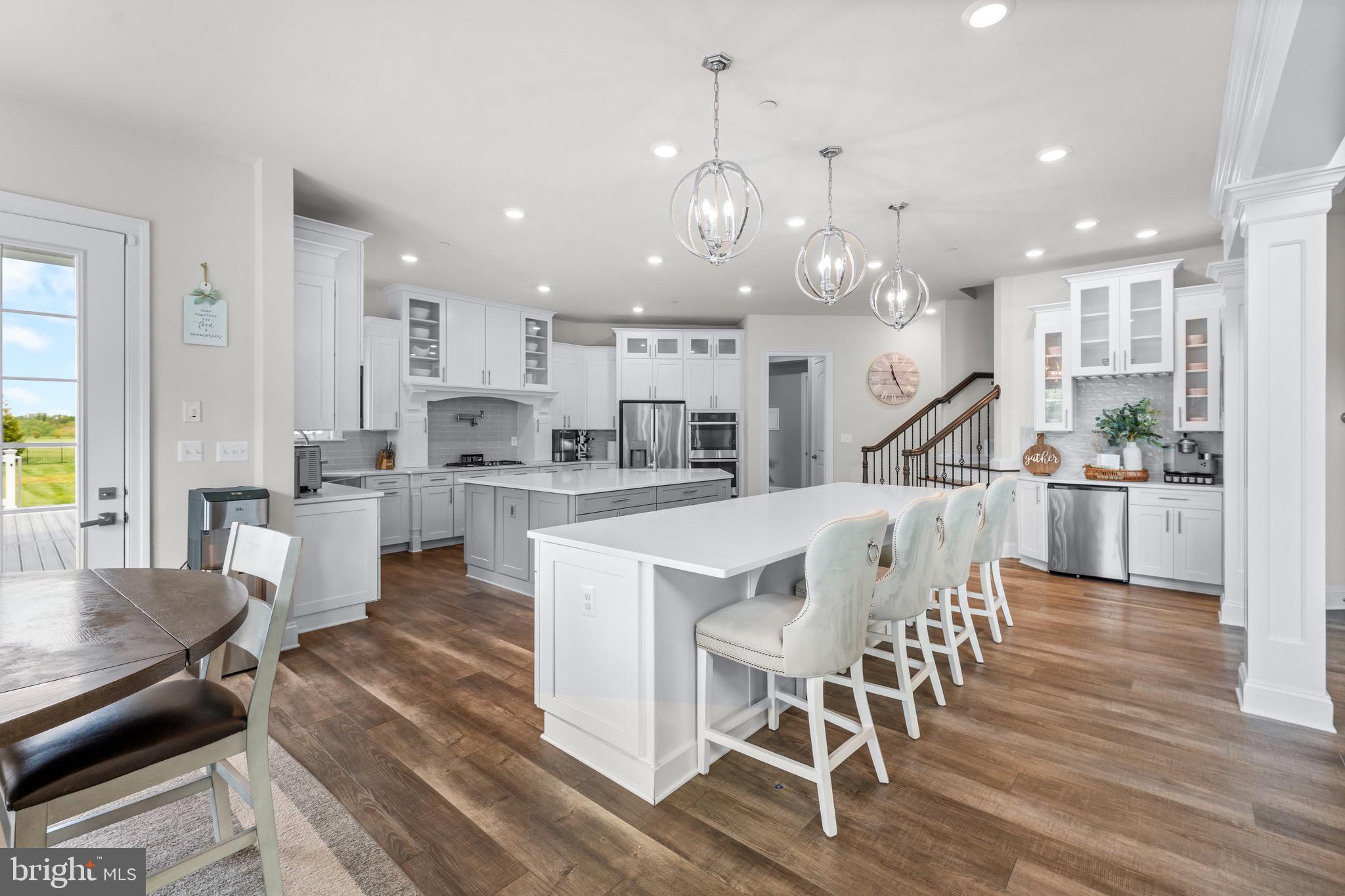 12201 Mayapple Trail Sykesville, MD 21784 - Photo 13 of 75 a kitchen with stainless steel appliances kitchen island granite countertop a dining table chairs and white cabinets