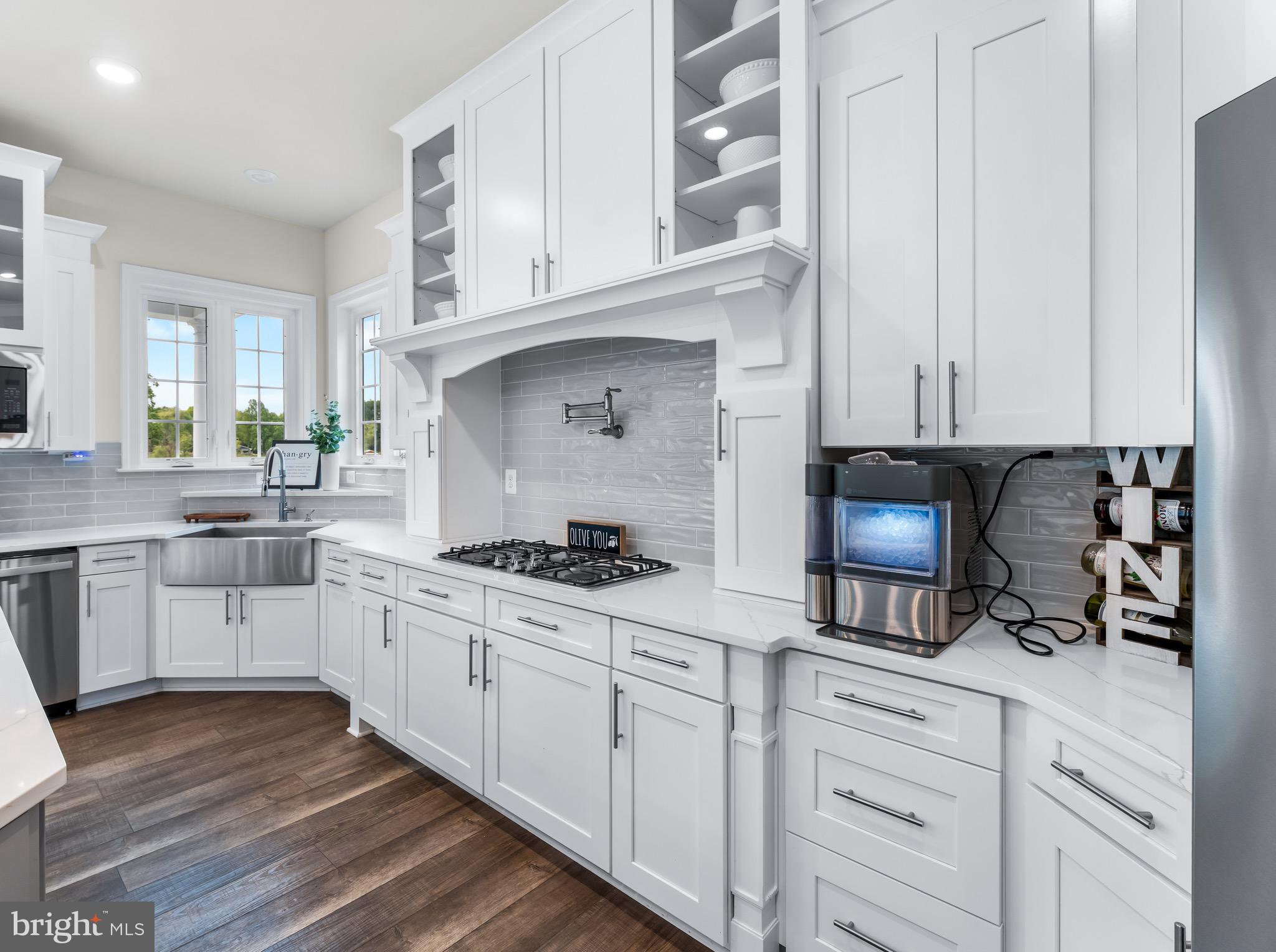 12201 Mayapple Trail Sykesville, MD 21784 - Photo 16 of 75 a kitchen with white cabinets and appliances