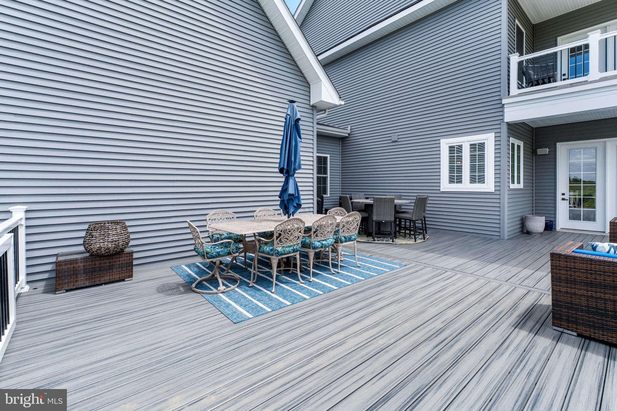 12201 Mayapple Trail Sykesville, MD 21784 - Photo 24 of 75 a view of a roof deck with table and chairs with wooden floor and floor to ceiling window