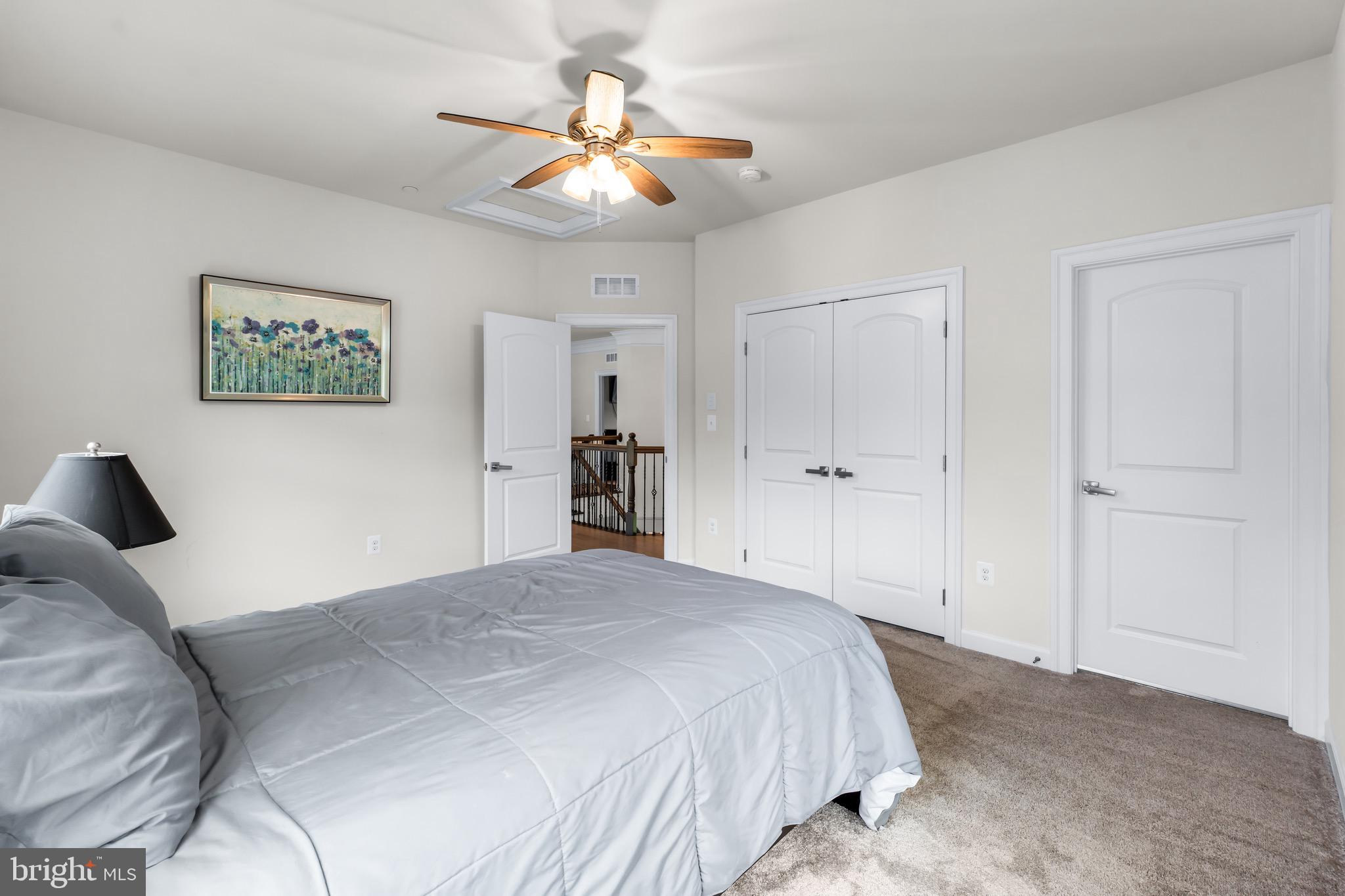 12201 Mayapple Trail Sykesville, MD 21784 - Photo 48 of 75 a bedroom with a large bed and a chandelier