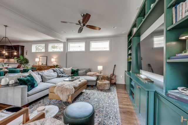 a living room with furniture a flat screen tv and kitchen view