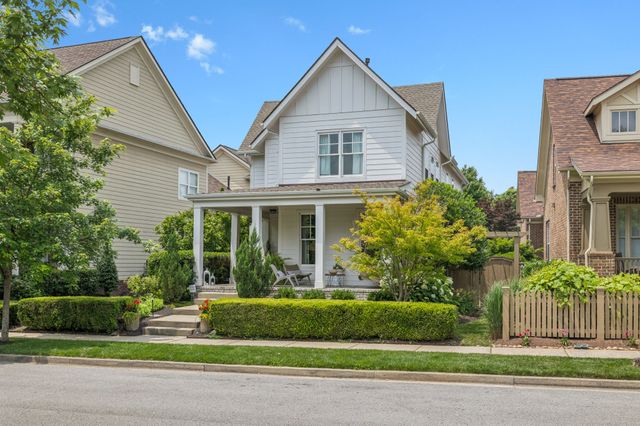 a front view of a house with a yard and potted plants