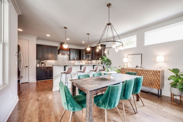 a kitchen with stainless steel appliances kitchen island granite countertop a stove a refrigerator and a wooden floor