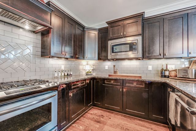 a bedroom with a bed and a potted plant on the dresser