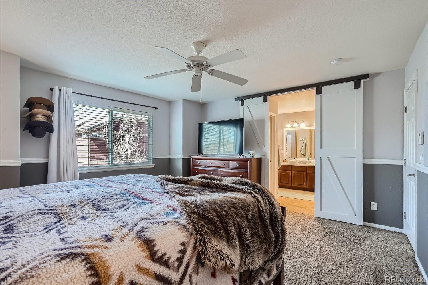 3085 Meadowbrook Place Dacono, CO 80514 - Photo 11 of 32 a bedroom with a large bed and a window