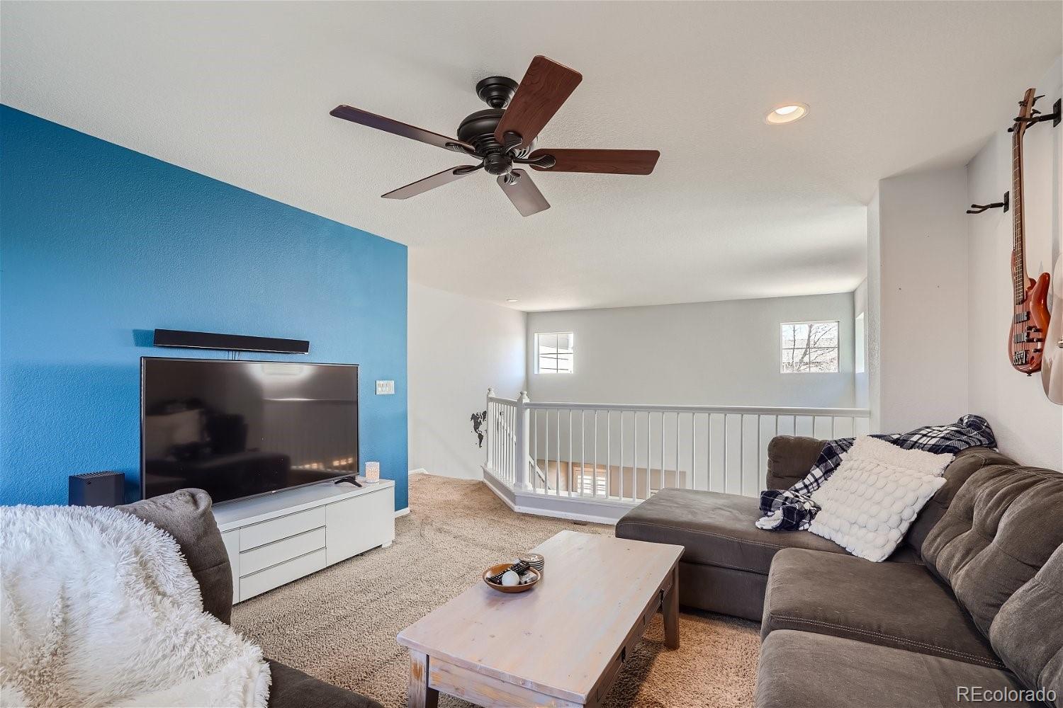 3085 Meadowbrook Place Dacono, CO 80514 - Photo 19 of 32 a living room with furniture and a flat screen tv