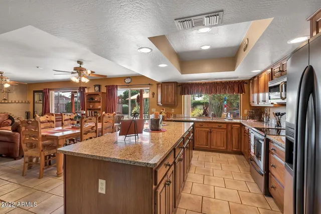 a kitchen with stainless steel appliances granite countertop a sink a stove and a refrigerator