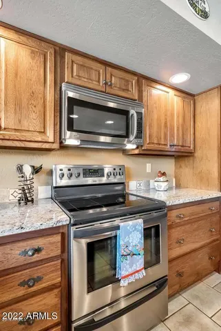 a kitchen with granite countertop a stove microwave and fridge