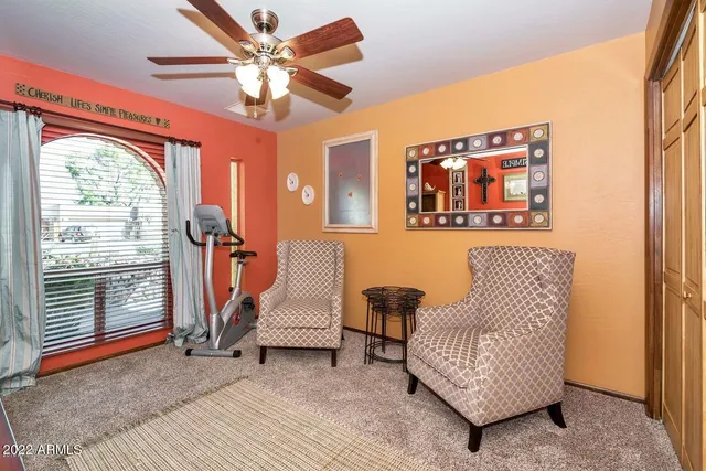 a living room with furniture a ceiling fan and a window