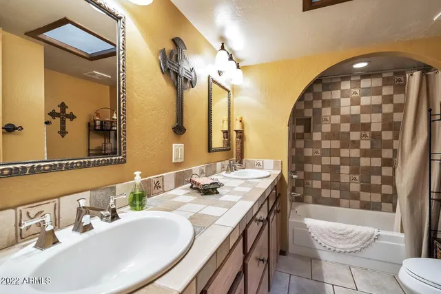 a bathroom with a sink a toilet and a mirror