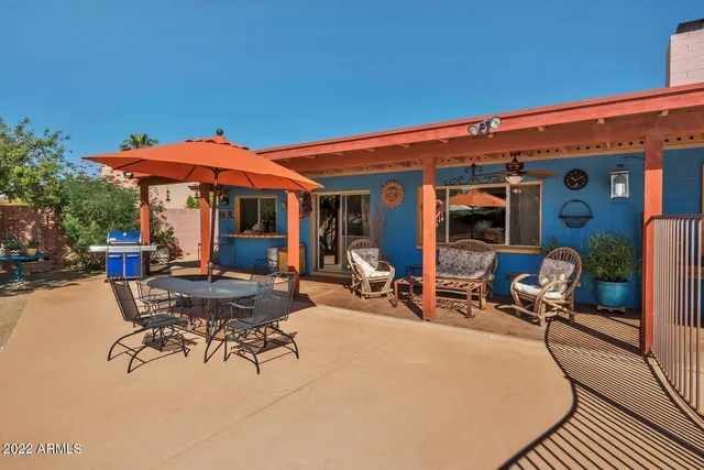 a view of a patio with table and chairs under an umbrella
