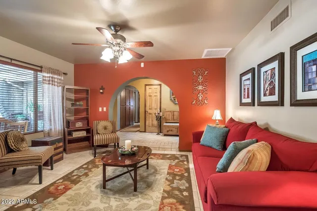 a living room with furniture a large window and a chandelier