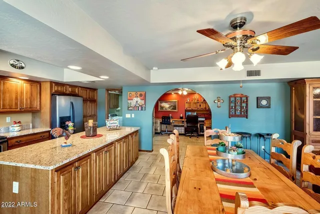 a open kitchen with stainless steel appliances granite countertop a stove a sink dishwasher and a dining table with the living room view