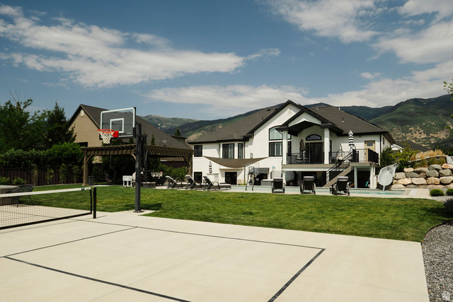 924 Country Lane Farmington, UT 84025 - Photo 80 of 91 Expansive backyard featuring a multi-sport court with a basketball hoop and net, a manicured lawn, and a large patio area with a swimming pool