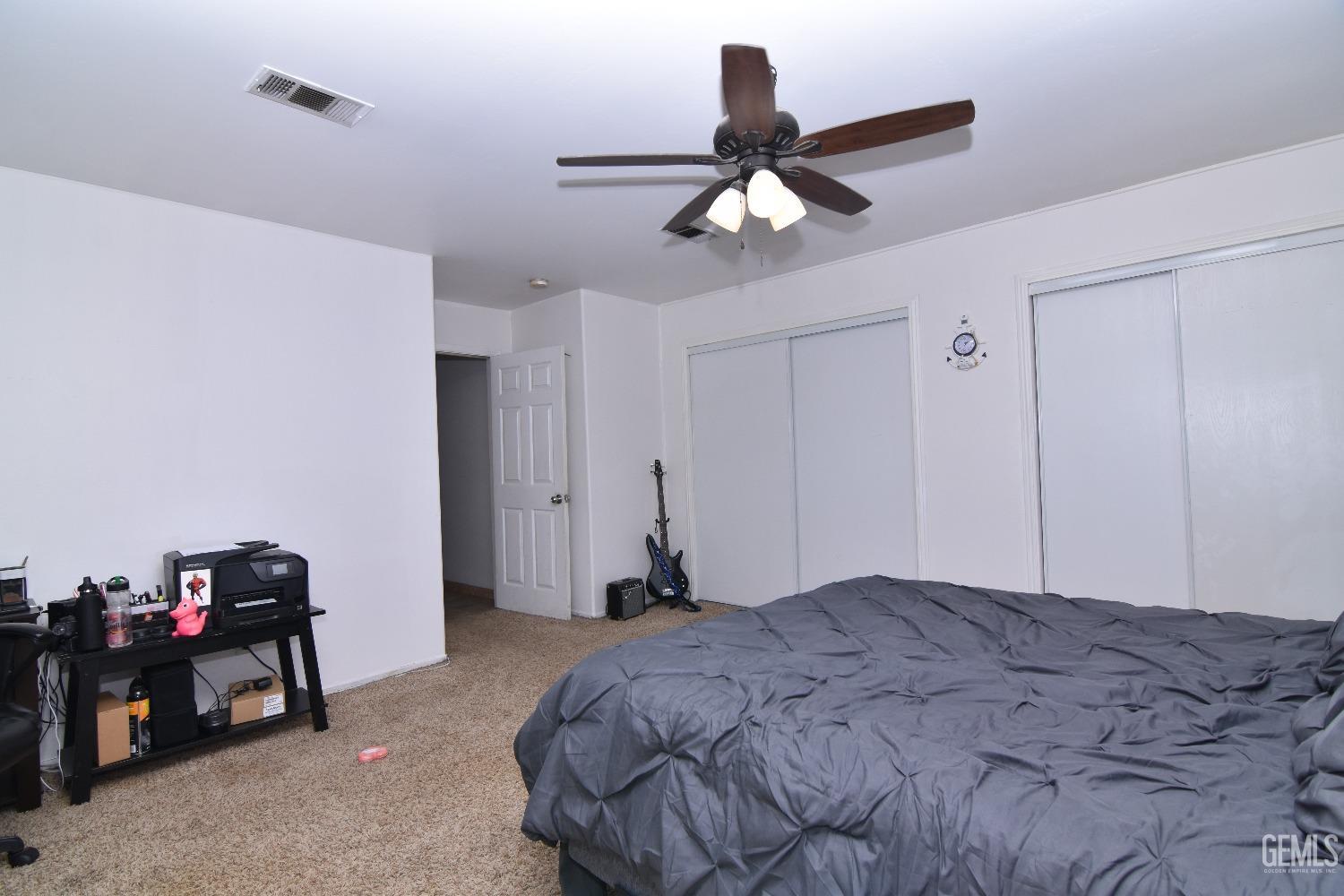 Undisclosed Address Bakersfield, CA 93313 - Photo 13 of 32 a bedroom with a bed and a chandelier