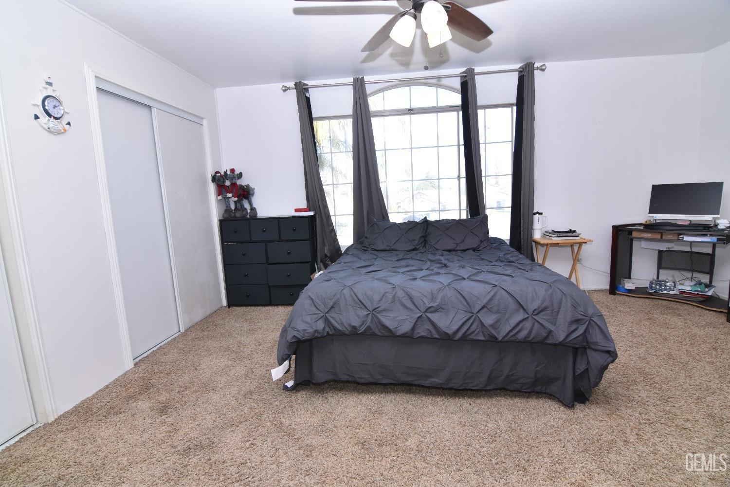 Undisclosed Address Bakersfield, CA 93313 - Photo 14 of 32 a spacious bedroom with a bed and a chandelier