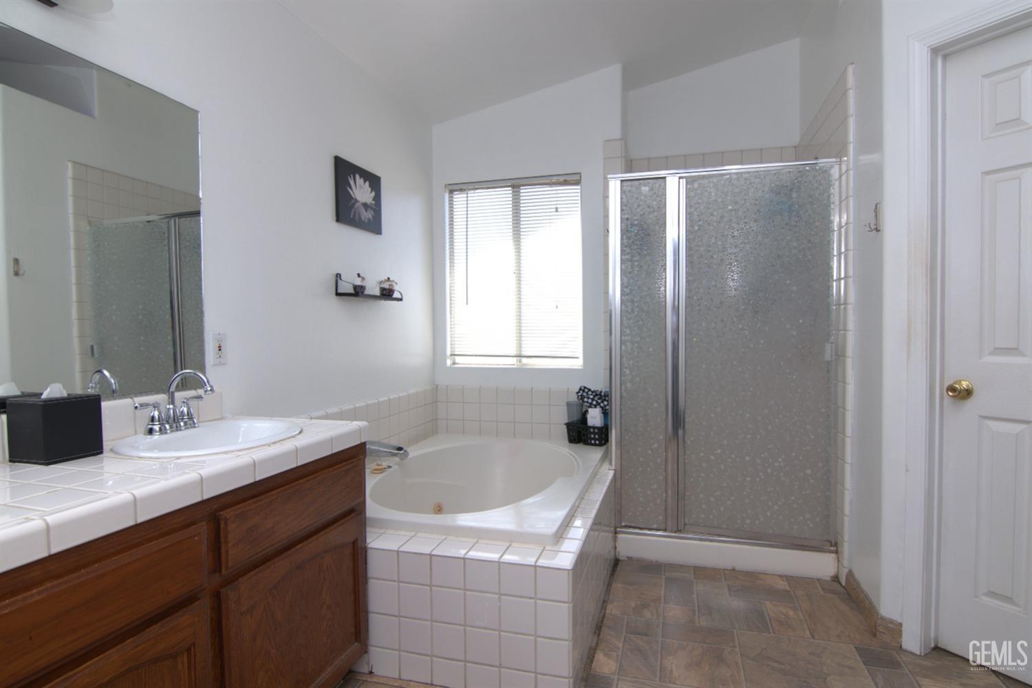 Undisclosed Address Bakersfield, CA 93313 - Photo 20 of 32 a bathroom with a tub sink and mirror