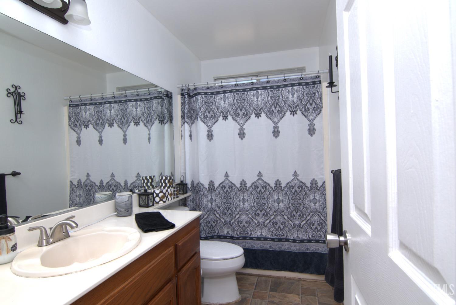 Undisclosed Address Bakersfield, CA 93313 - Photo 25 of 32 a bathroom with a granite countertop sink and a mirror