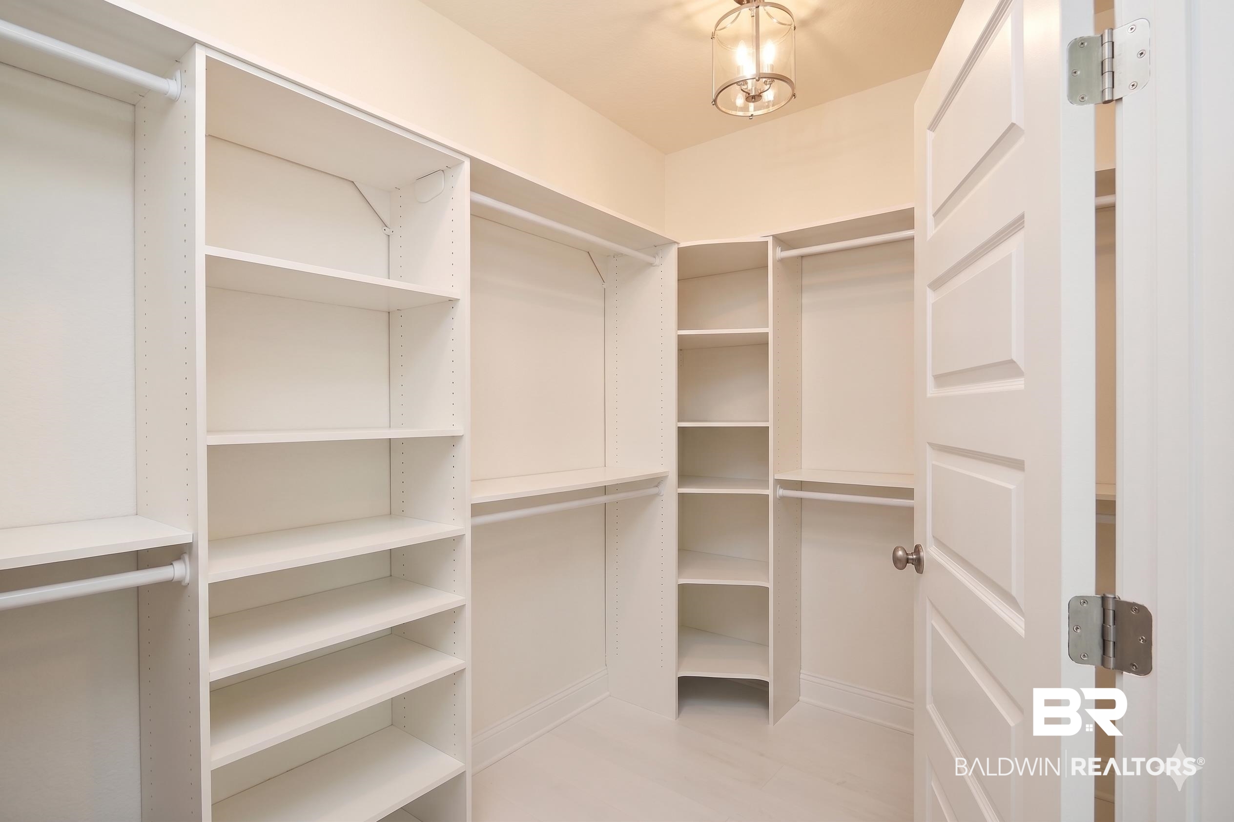 1885 Carly Street Foley, AL 36535 - Photo 21 of 40 Walk-in closet featuring extensive built-in shelving, multiple hanging rods, and a white paneled door