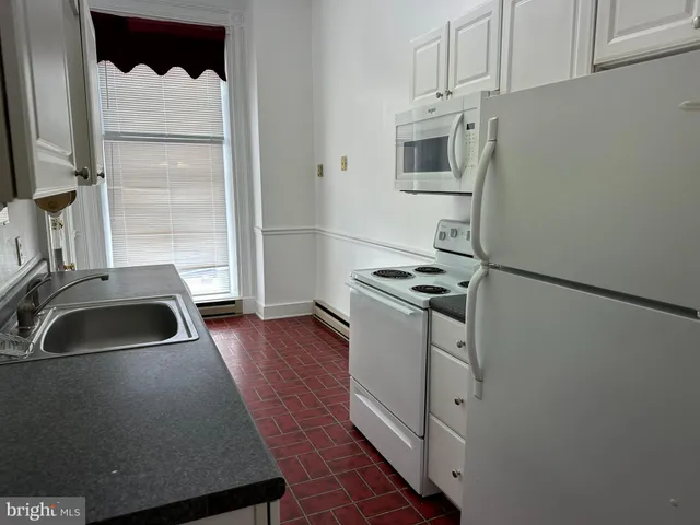a kitchen with sink a refrigerator and cabinets