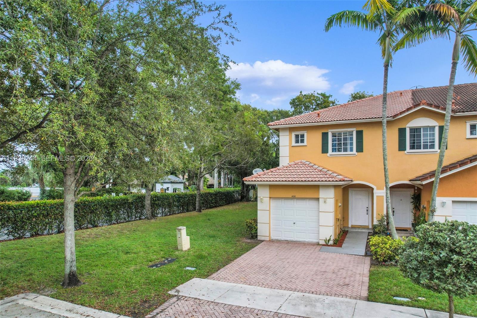 400 Princess Drive Margate, FL 33068 - Photo 17 of 26 a front view of a house with a garden and yard