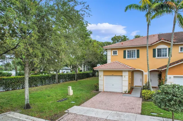a front view of a house with a garden and yard