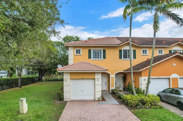 a front view of a house with a garden and yard
