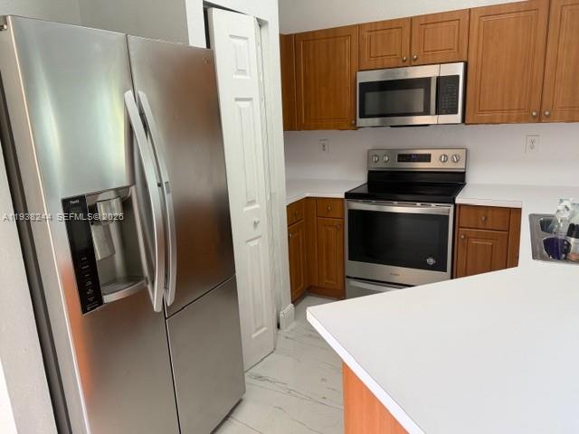 400 Princess Drive Margate, FL 33068 - Photo 24 of 26 a kitchen with stainless steel appliances a refrigerator microwave and sink