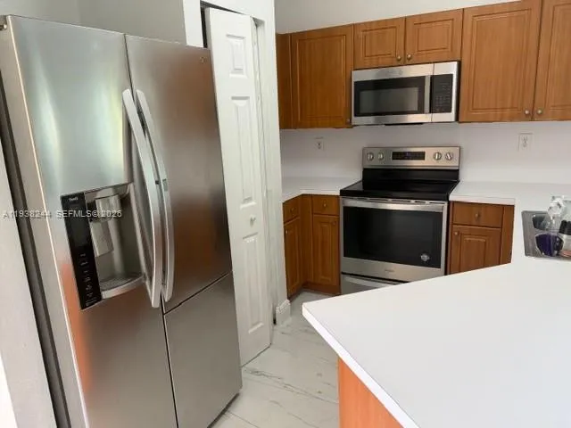 a kitchen with stainless steel appliances a refrigerator microwave and sink