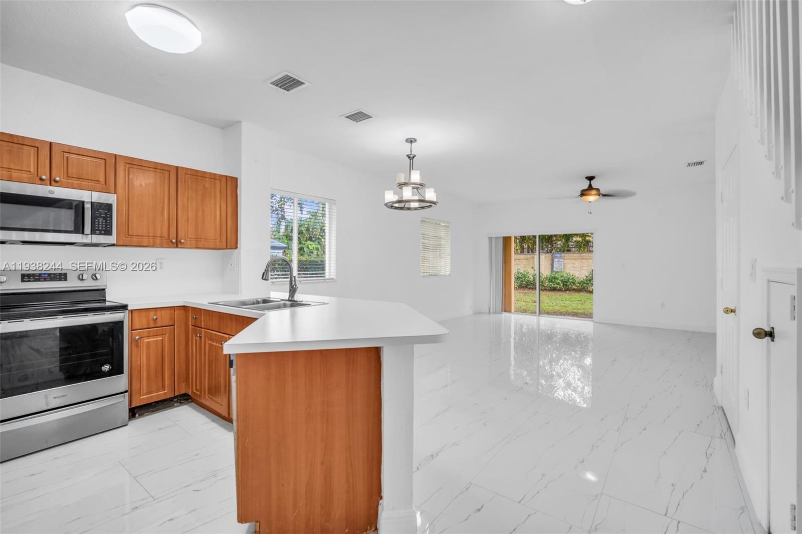 400 Princess Drive Margate, FL 33068 - Photo 4 of 26 a kitchen with kitchen island granite countertop a stove a sink and a refrigerator