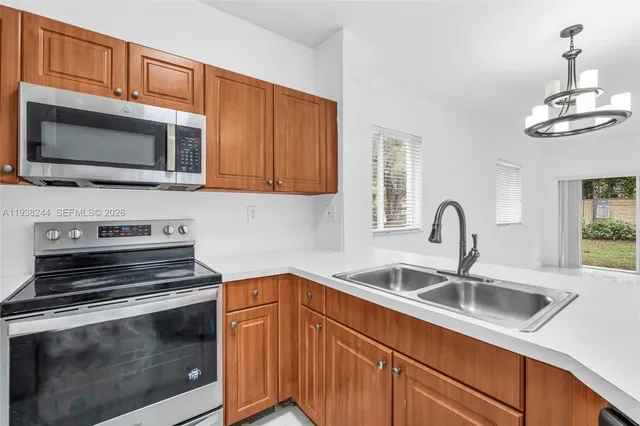 a kitchen with stainless steel appliances a stove microwave and sink