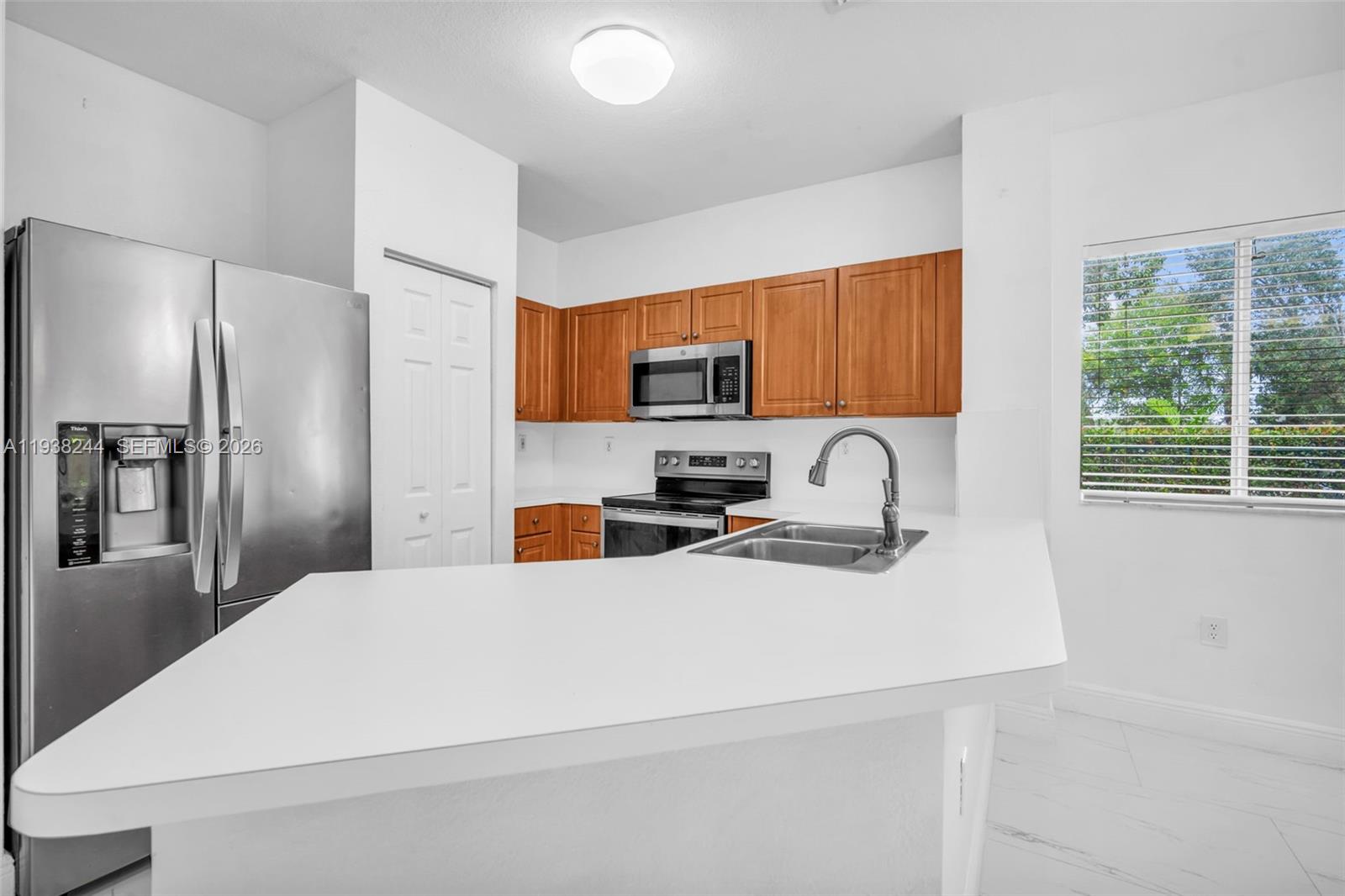 400 Princess Drive Margate, FL 33068 - Photo 6 of 26 a kitchen with stainless steel appliances a refrigerator sink and wooden cabinets