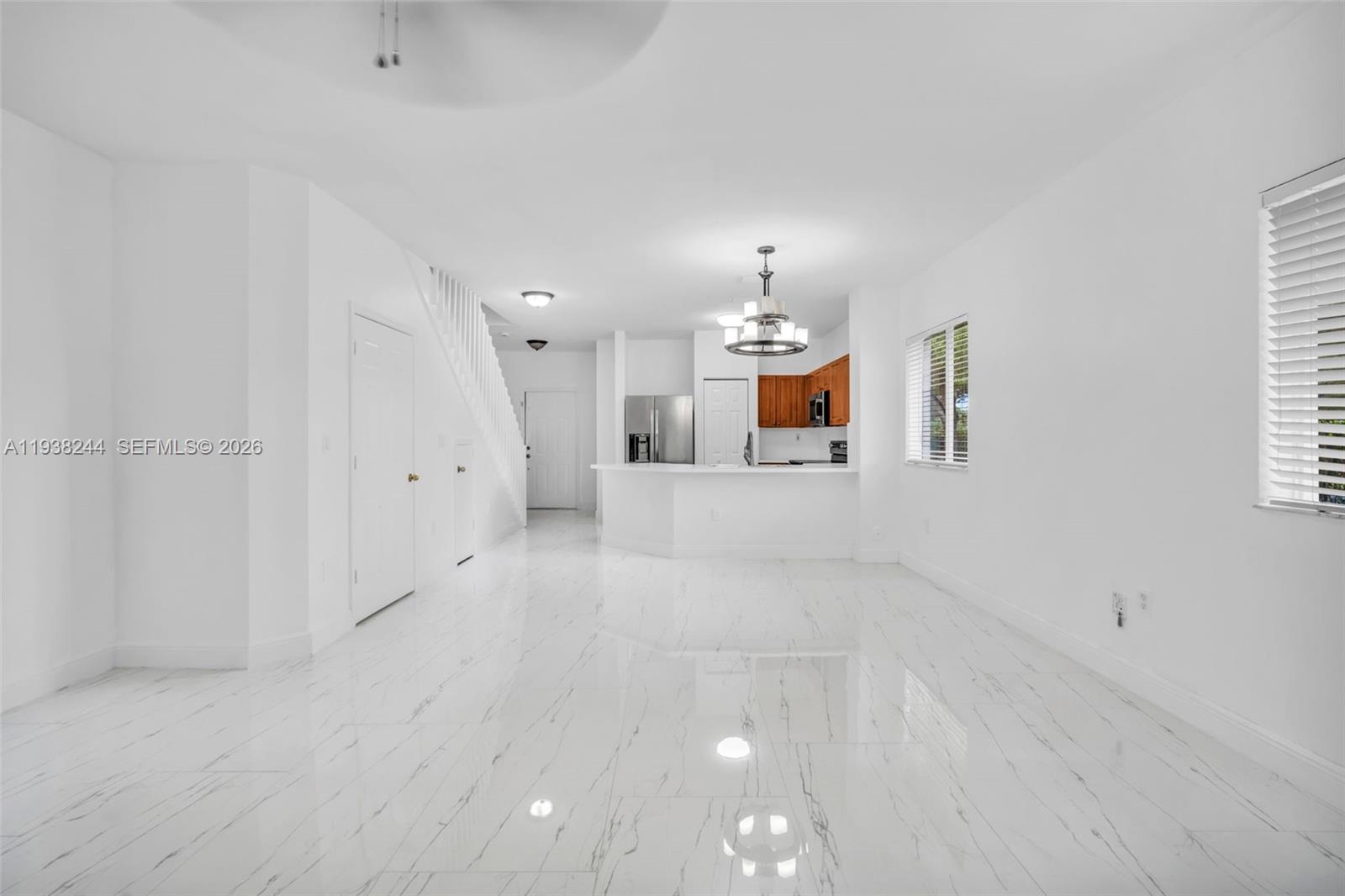 400 Princess Drive Margate, FL 33068 - Photo 7 of 26 an empty room with chandelier fan and windows