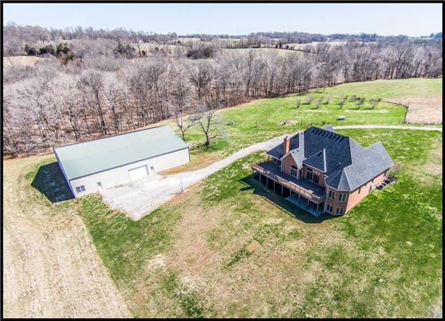 5108 Drake Road Cedar Hill, TN 37032 - Photo 14 of 20 Rear of home and large building showing Trex deck with patio below. The orchard with berry patch is visible at the top of the photo.
