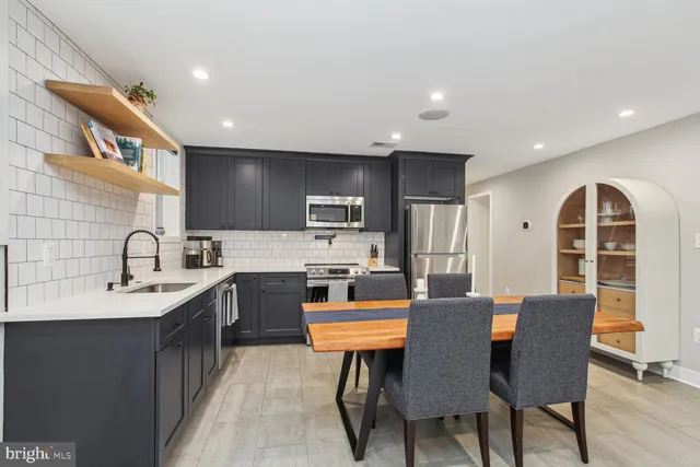 a kitchen with stainless steel appliances granite countertop a sink stove and microwave