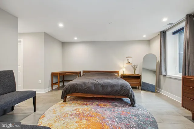 a bedroom with a bed a couch and dresser