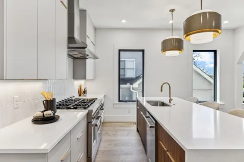a kitchen with granite countertop a sink stainless steel appliances and cabinets