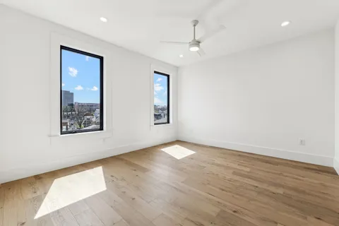 an empty room with wooden floor and fireplace