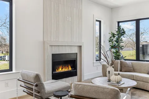 a living room with furniture a ceiling fan and a fireplace