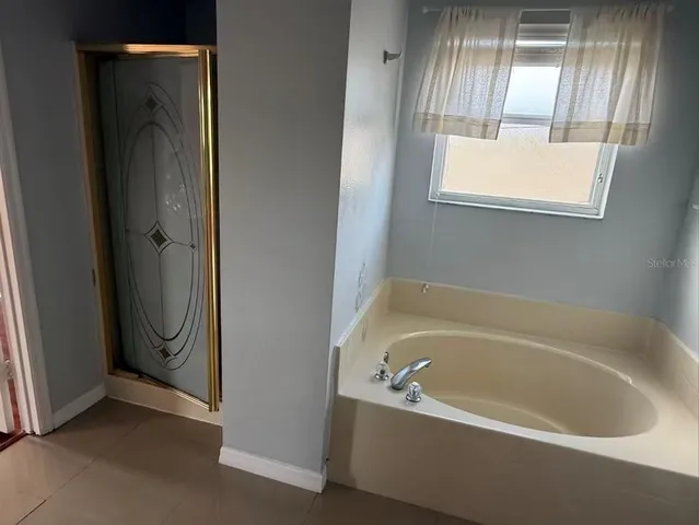 a bathroom with bathtub and window