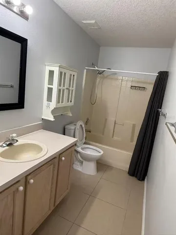 a bathroom with a sink a toilet a mirror and shower