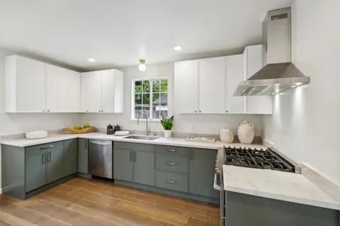 a kitchen with a sink a stove and cabinets