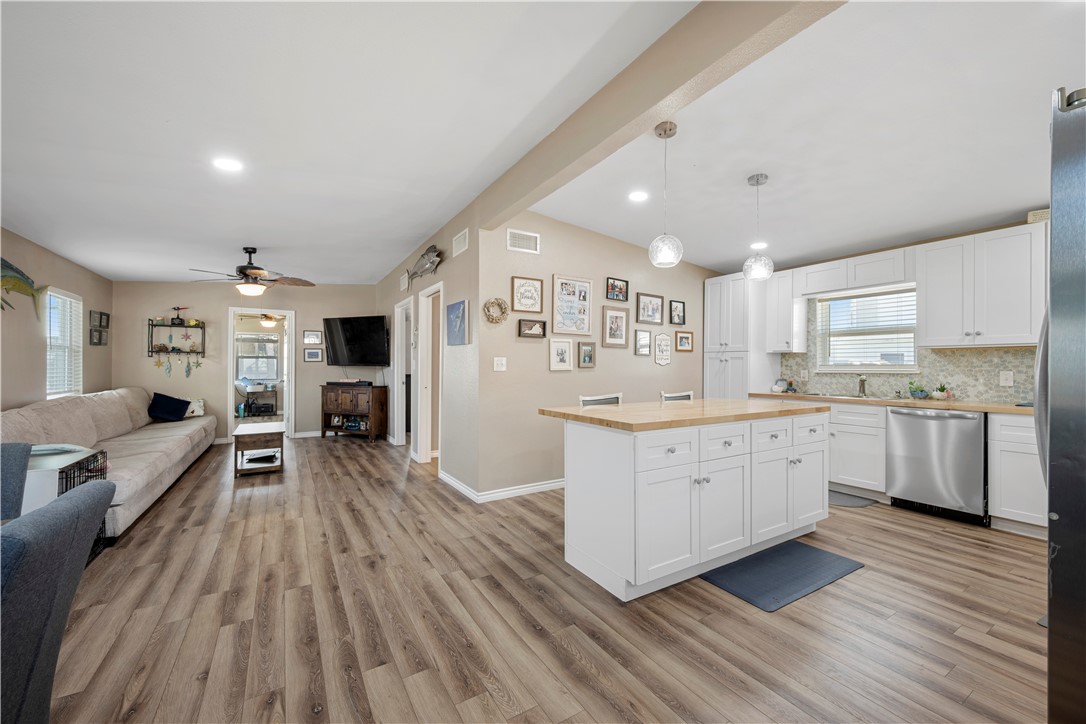 622 South Sandpiper Ingleside, TX 78362 - Photo 10 of 38 a kitchen with white cabinets and wooden floor