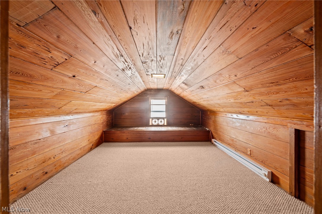3261 Berea Road Cleveland, OH 44111 - Photo 25 of 43 Vaulted ceiling with wood paneling, wood-paneled walls, carpeted flooring, and an integrated window