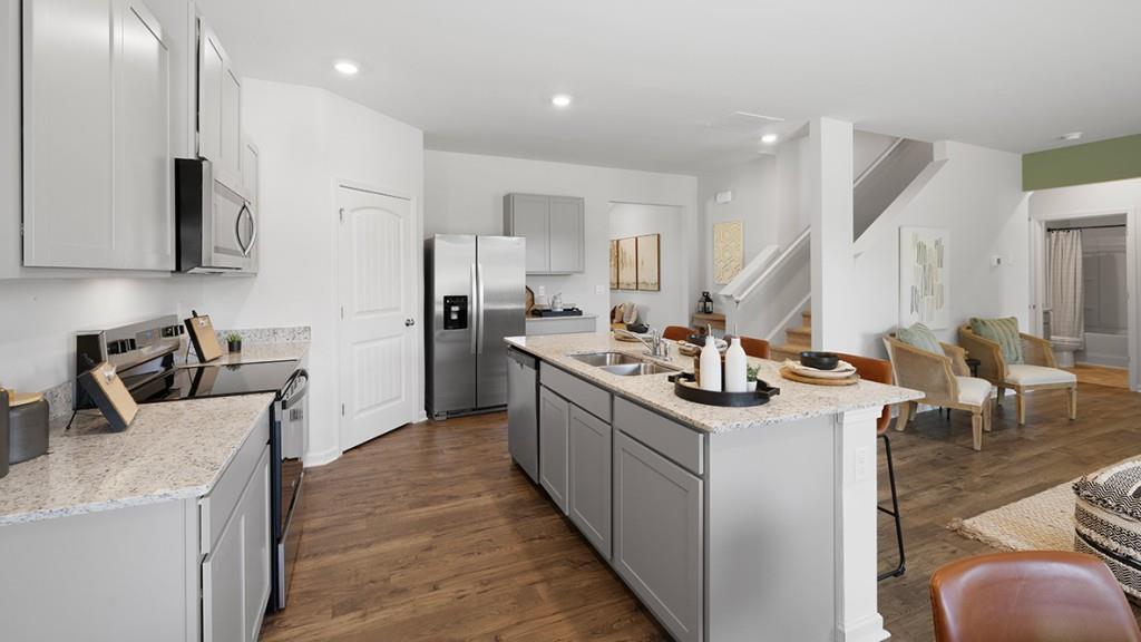 3863 Donetta Drive Atlanta, GA 30349 - Photo 8 of 64 a kitchen with stainless steel appliances kitchen island granite countertop a sink and a stove top oven with wooden floor