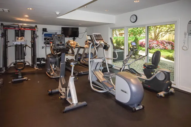 a living room with furniture a flat screen tv and a large window