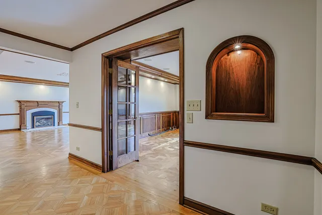 a big room with wooden floor a fireplace and windows