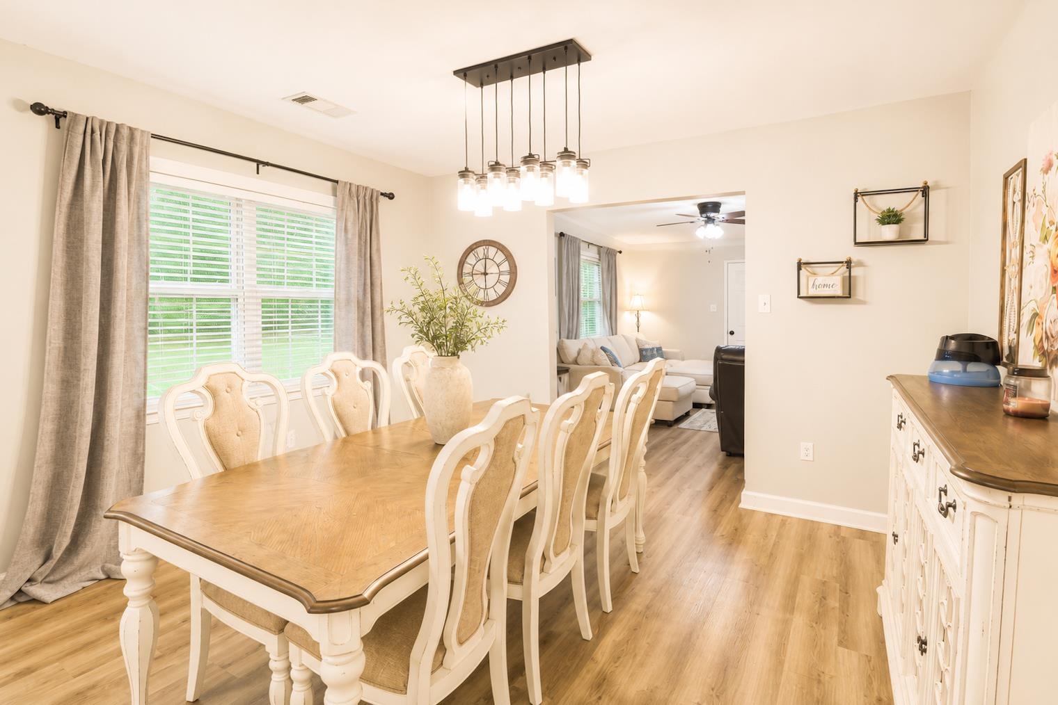 10093 Mt Carmel Road Brighton, TN 38011 - Photo 16 of 36 Dining area featuring wood-finish flooring, a multi-light linear chandelier, and a wide window with blinds