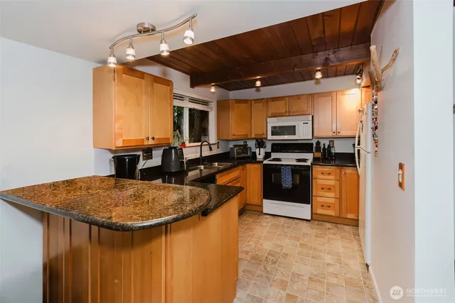 a kitchen with stainless steel appliances granite countertop a sink and a refrigerator
